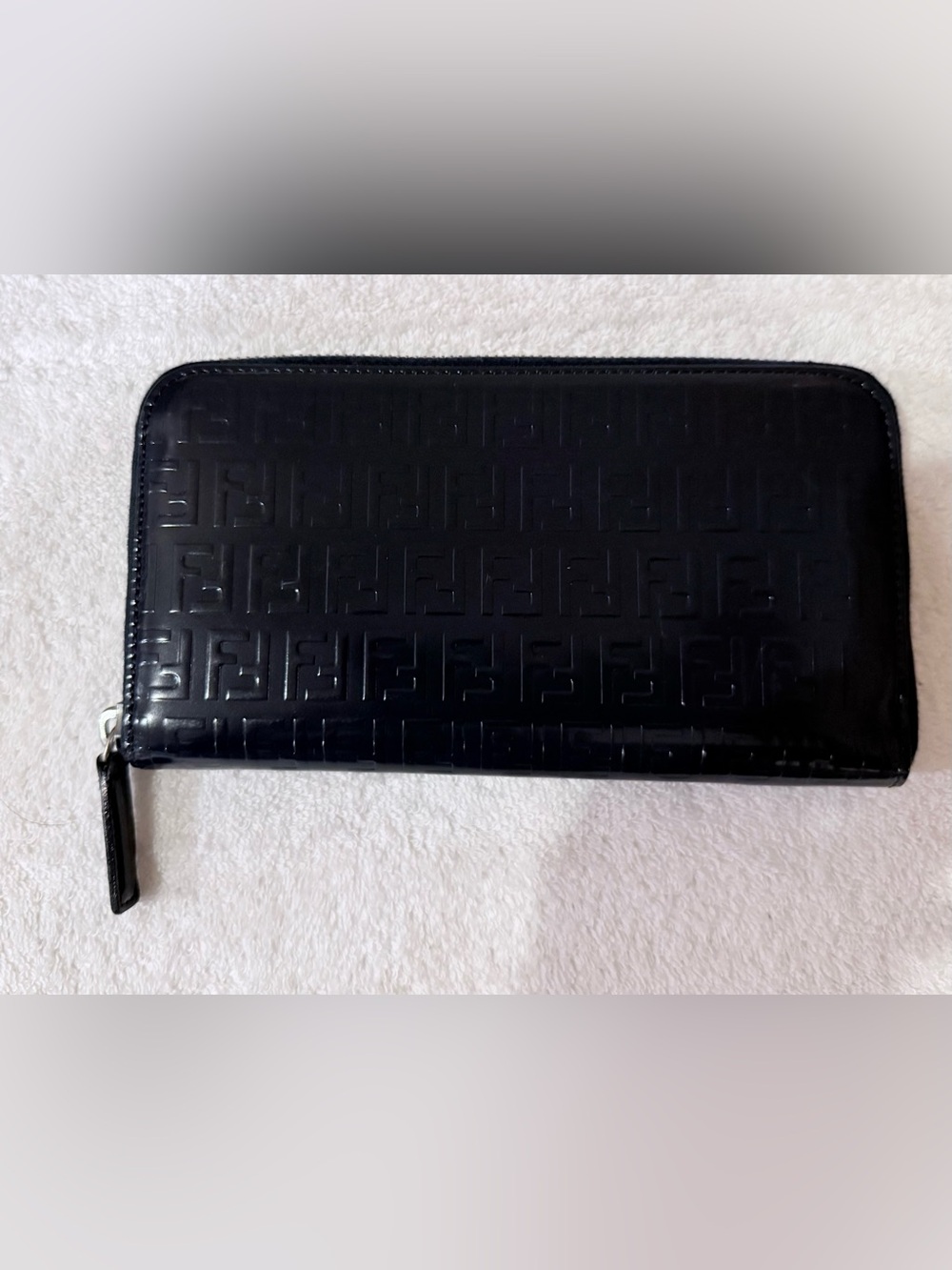 Fendi long zip-around wallet featuring an embossed Zucca logo pattern